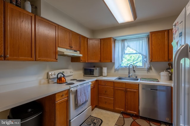 419 S Wyomissing Ave, Reading, PA 19607 - kitchen with white appliances, a sink, under cabinet range hood, light countertops, and brown cabinets