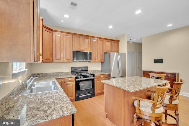 332 Blanketflower Ln, West Windsor, NJ 08550 - kitchen with stainless steel appliances, a sink, light wood-type flooring, a kitchen bar, and a center island