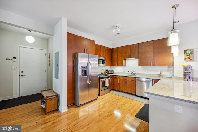 8005 13th St Unit 411, Silver Spring, MD 20910 - kitchen with appliances with stainless steel finishes, light wood finished floors, pendant lighting, and light stone counters