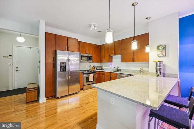 8005 13th St Unit 411, Silver Spring, MD 20910 - kitchen featuring stainless steel appliances, a sink, a peninsula, a kitchen breakfast bar, and light wood-style floors