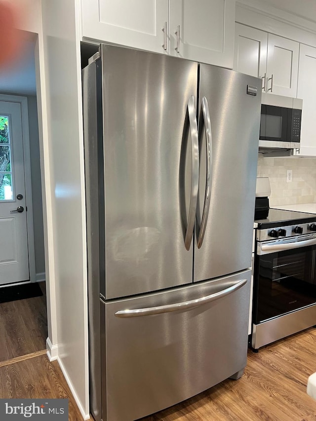 34 Hornets Nest Ln, Fredericksburg, VA 22405 - kitchen with appliances with stainless steel finishes, wood finished floors, white cabinetry, and backsplash
