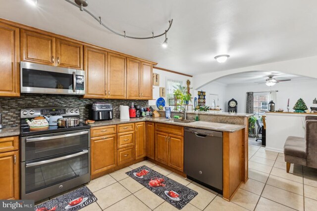 11617 Smithfield Rd, Manassas, VA 20112 - kitchen with appliances with stainless steel finishes, a sink, brown cabinets, a peninsula, and crown molding