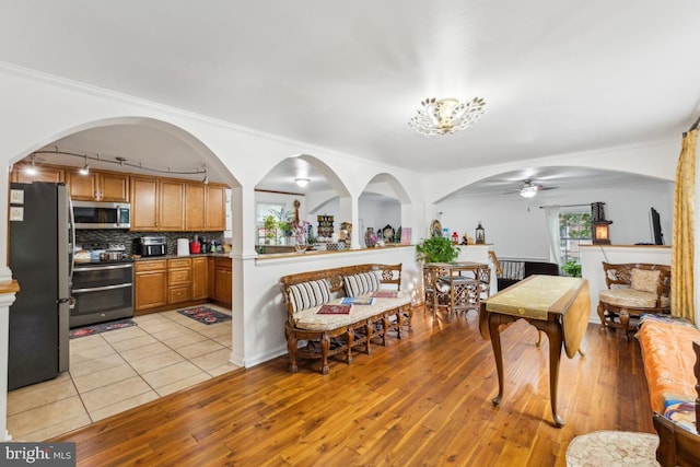 11617 Smithfield Rd, Manassas, VA 20112 - dining space featuring light wood-style floors, ceiling fan, and arched walkways