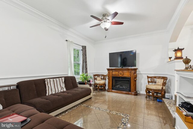 11617 Smithfield Rd, Manassas, VA 20112 - living room featuring a glass covered fireplace, crown molding, ceiling fan, and a wainscoted wall