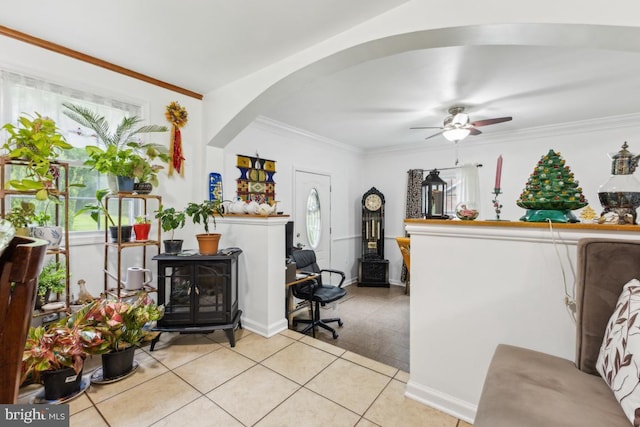 11617 Smithfield Rd, Manassas, VA 20112 - living room with arched walkways, crown molding, a wood stove, ceiling fan, and light tile patterned floors
