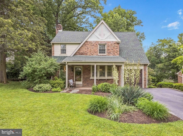 727 Hemlock Rd, Media, PA 19063 - view of front of property with a chimney, driveway, a front lawn, and brick siding