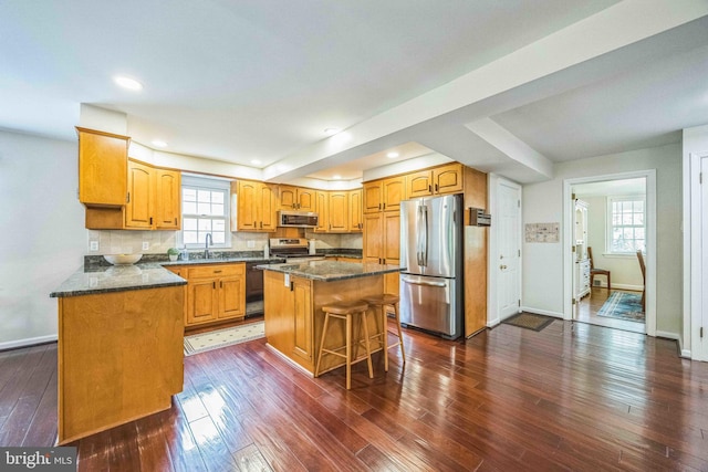 727 Hemlock Rd, Media, PA 19063 - kitchen featuring stainless steel appliances, baseboards, dark wood-style flooring, recessed lighting, and a breakfast bar