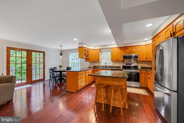 727 Hemlock Rd, Media, PA 19063 - kitchen featuring appliances with stainless steel finishes, a peninsula, dark wood-style floors, dark stone counters, and recessed lighting