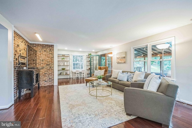 727 Hemlock Rd, Media, PA 19063 - living area featuring dark wood-style flooring, baseboards, brick wall, and a wood stove