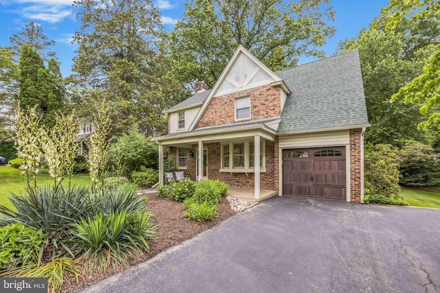 727 Hemlock Rd, Media, PA 19063 - view of front facade featuring a garage, covered porch, asphalt driveway, a chimney, and brick siding