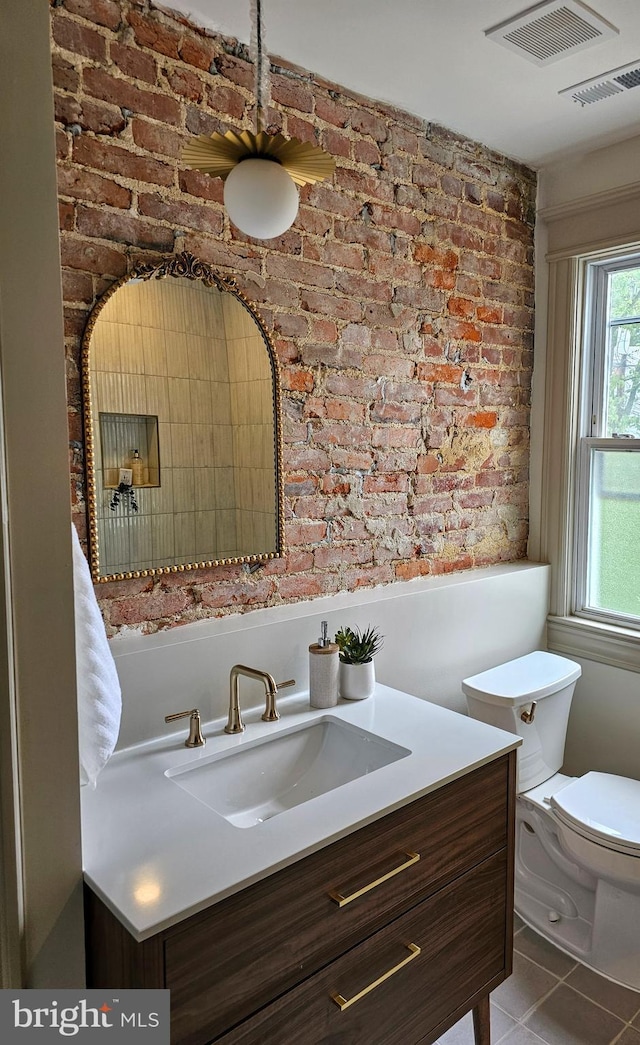 110 Varnum St NW, Washington, DC 20011 - bathroom with vanity, brick wall, tile patterned flooring, and toilet