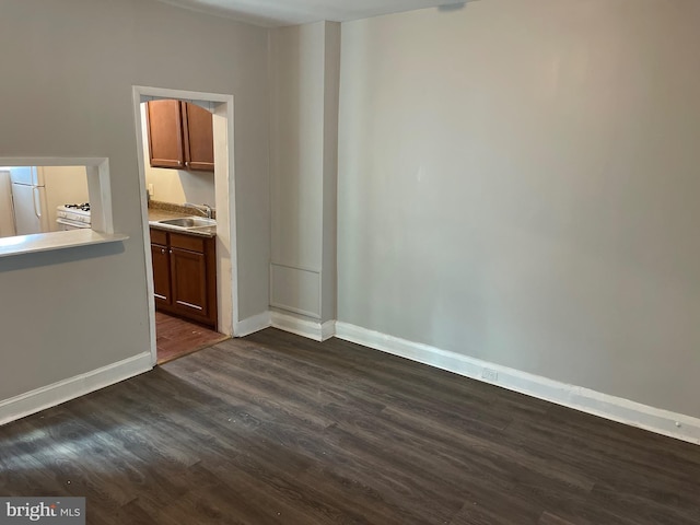 3414 Cardenas Ave, Baltimore, MD 21213 - unfurnished living room featuring a sink, dark wood-style flooring, and baseboards