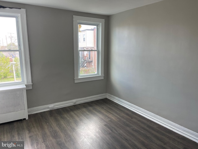 3414 Cardenas Ave, Baltimore, MD 21213 - spare room featuring radiator heating unit, healthy amount of natural light, dark wood-style floors, and baseboards