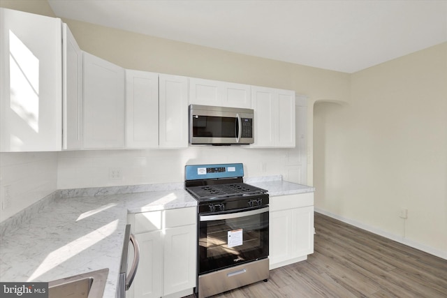 443 N 2nd St, Wormleysburg, PA 17043 - kitchen with appliances with stainless steel finishes, light stone counters, backsplash, and white cabinetry