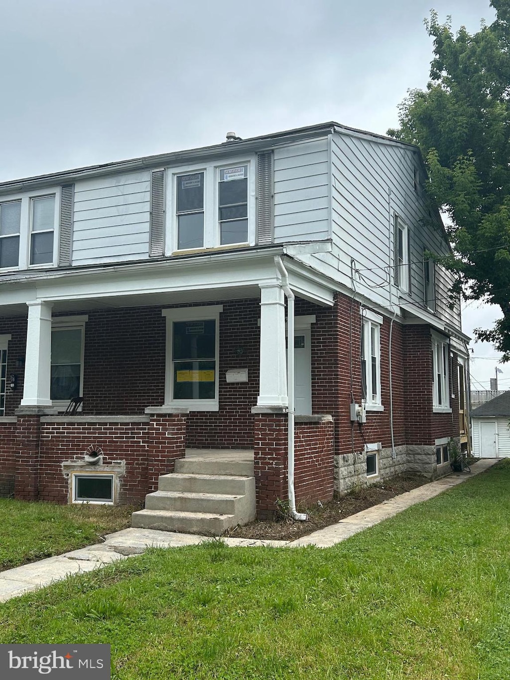 443 N 2nd St, Wormleysburg, PA 17043 - view of front facade featuring brick siding, a front lawn, and a porch