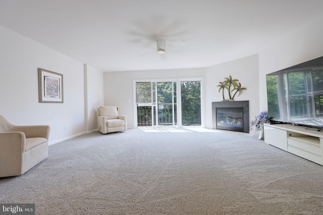 17455 Kagera Dr, Dumfries, VA 22025 - living area featuring a glass covered fireplace, carpet flooring, a ceiling fan, and baseboards