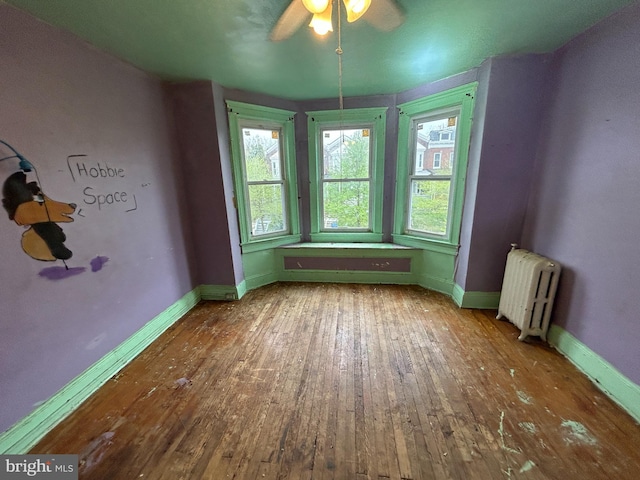 2904 Winchester St, Baltimore, MD 21216 - empty room featuring radiator heating unit, wood-type flooring, ceiling fan, and baseboards