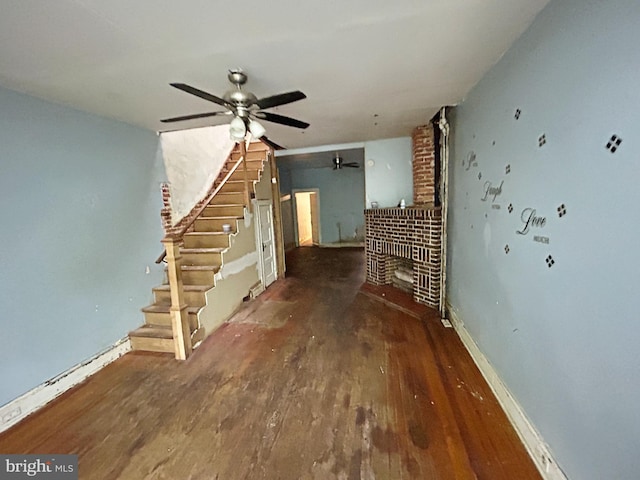 2904 Winchester St, Baltimore, MD 21216 - unfurnished living room featuring wood finished floors, stairway, ceiling fan, a fireplace, and baseboards