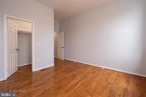 1743 E Oliver St, Baltimore, MD 21213 - unfurnished bedroom with wood finished floors, a walk in closet, and a closet