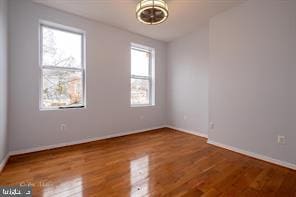 1743 E Oliver St, Baltimore, MD 21213 - unfurnished room featuring wood finished floors and a chandelier