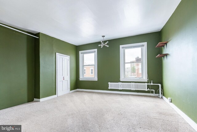 2014 N 4th St, Philadelphia, PA 19122 - unfurnished room with radiator heating unit, carpet flooring, a chandelier, and baseboards