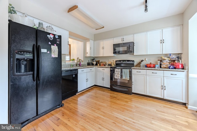 6150 Castletown Way, Alexandria, VA 22310 - kitchen featuring black appliances, white cabinetry, light wood finished floors, light stone counters, and a sink