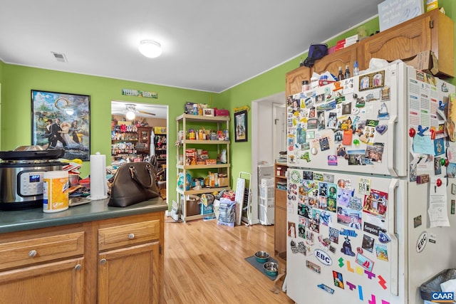 13 Tobacco Ter, Palmyra, VA 22963 - kitchen with freestanding refrigerator, light wood-style flooring, brown cabinets, and dark countertops