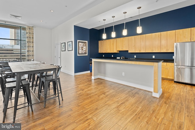 414 Water St Unit 1112, Baltimore, MD 21202 - kitchen with freestanding refrigerator, light brown cabinetry, dark countertops, baseboards, and recessed lighting