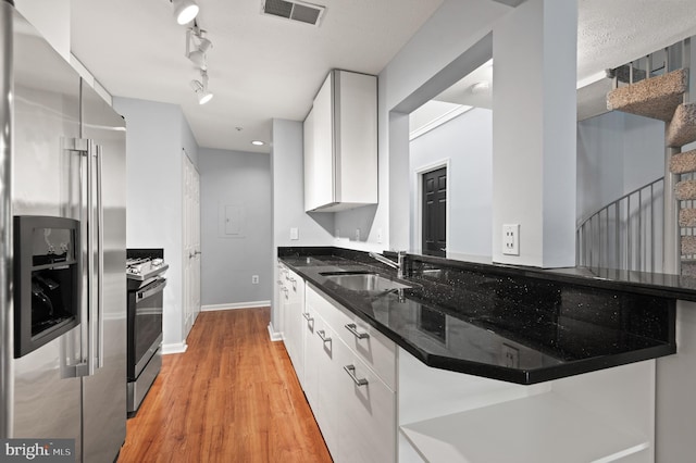 2000 Phillips Ter Unit 12, Annapolis, MD 21401 - kitchen with appliances with stainless steel finishes, a sink, white cabinetry, light wood-type flooring, and dark stone countertops