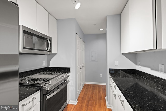 2000 Phillips Ter Unit 12, Annapolis, MD 21401 - kitchen featuring appliances with stainless steel finishes, white cabinets, light wood finished floors, dark stone counters, and baseboards