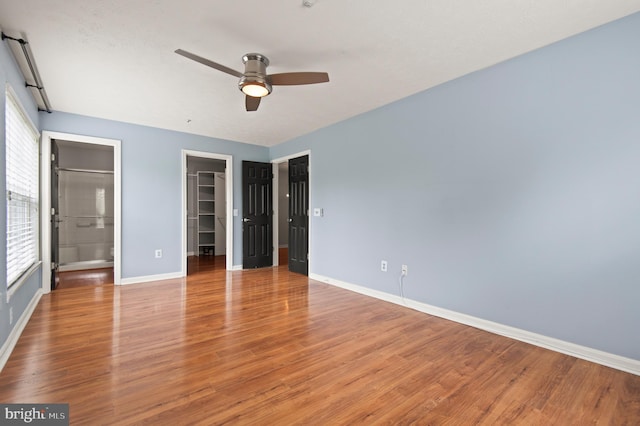 2000 Phillips Ter Unit 12, Annapolis, MD 21401 - unfurnished bedroom with baseboards, wood finished floors, a walk in closet, a closet, and ceiling fan