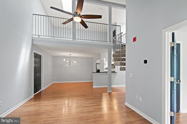 2000 Phillips Ter Unit 12, Annapolis, MD 21401 - unfurnished living room featuring a ceiling fan, a towering ceiling, wood finished floors, baseboards, and stairs