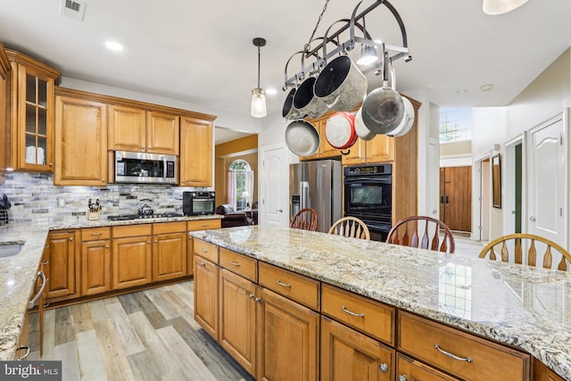 148 Ryans Run, Sicklerville, NJ 08081 - kitchen featuring stainless steel appliances, backsplash, light wood-style flooring, light stone counters, and brown cabinetry