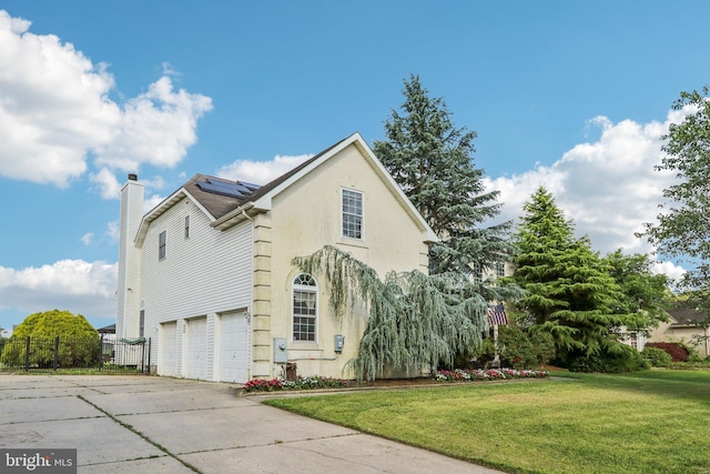 148 Ryans Run, Sicklerville, NJ 08081 - view of side of home with an attached garage, roof mounted solar panels, a chimney, concrete driveway, and stucco siding