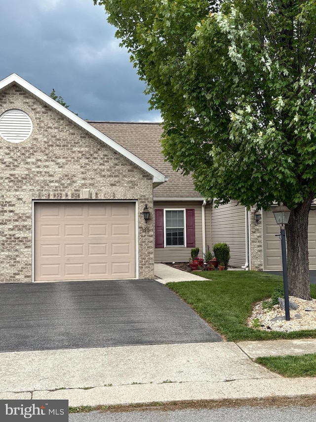 120 Brighton Dr, Carlisle, PA 17015 - single story home with asphalt driveway, a shingled roof, a garage, a front yard, and brick siding
