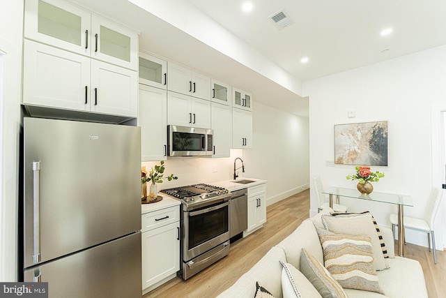 2517 Ontario Rd NW Unit 5, Washington, DC 20009 - kitchen featuring appliances with stainless steel finishes, a sink, light wood-style flooring, recessed lighting, and white cabinetry