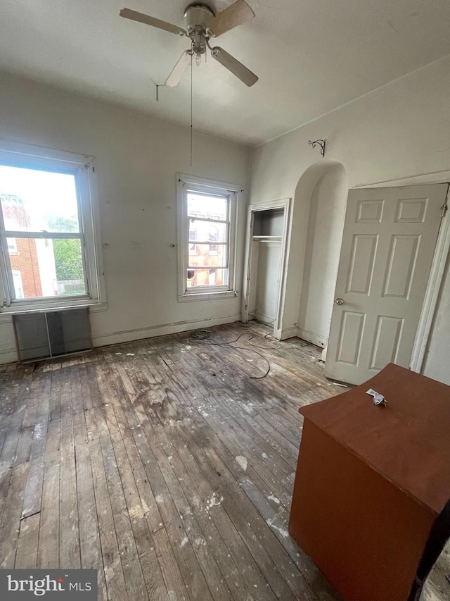 2408 N 15th St, Philadelphia, PA 19132 - unfurnished dining area with wood-type flooring, a ceiling fan, healthy amount of natural light, and arched walkways