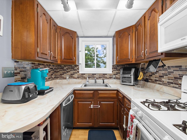 1016 Elm Rd, Halethorpe, MD 21227 - kitchen with white appliances, a sink, backsplash, and brown cabinetry
