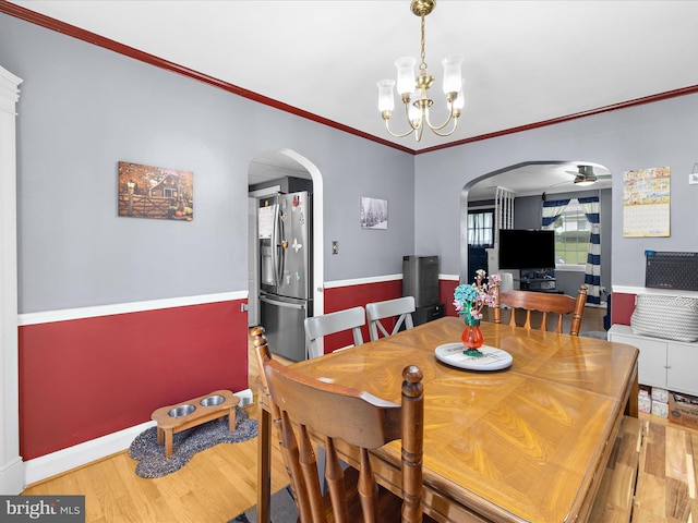 1016 Elm Rd, Halethorpe, MD 21227 - dining room featuring arched walkways, wood finished floors, a chandelier, ornamental molding, and a ceiling fan
