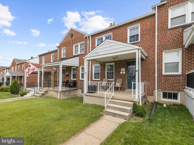 1016 Elm Rd, Halethorpe, MD 21227 - view of property featuring covered porch, brick siding, and a front yard