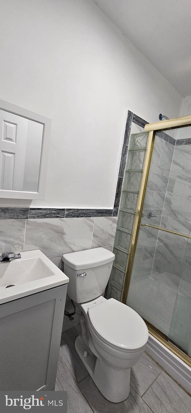 2540 W Silver St, Philadelphia, PA 19132 - full bath featuring tile walls, toilet, a stall shower, vanity, and wainscoting