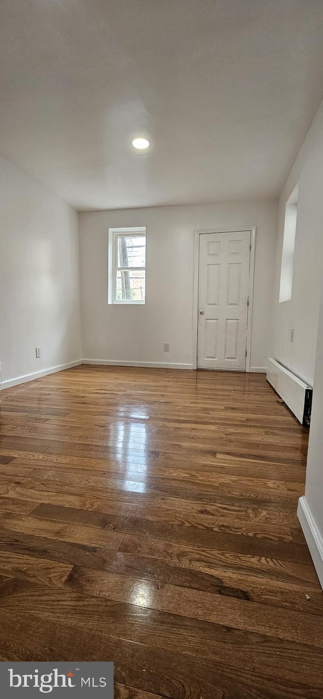 2540 W Silver St, Philadelphia, PA 19132 - spare room with baseboards, a baseboard radiator, dark wood-style flooring, and recessed lighting