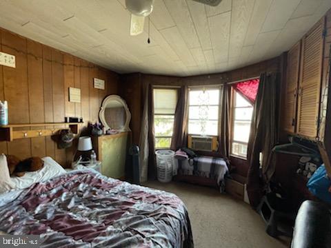 319 Linden St, Reading, PA 19604 - bedroom featuring carpet floors, wood walls, and cooling unit