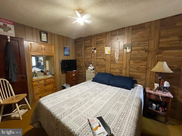319 Linden St, Reading, PA 19604 - bedroom with wooden walls and a textured ceiling