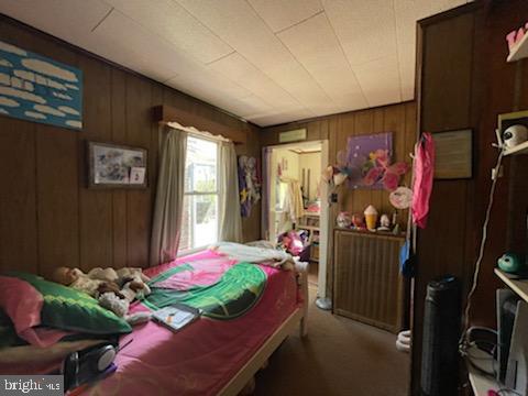 319 Linden St, Reading, PA 19604 - bedroom with carpet and wood walls