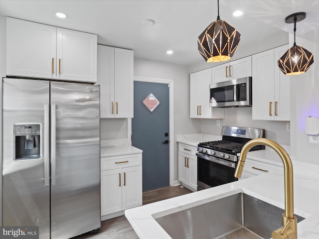 610 Galveston Pl SE, Washington, DC 20032 - kitchen with stainless steel appliances, a sink, white cabinets, light stone counters, and recessed lighting