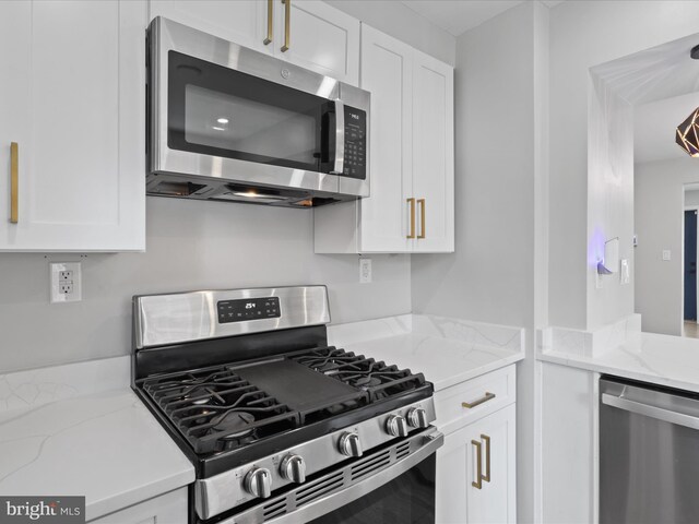 610 Galveston Pl SE, Washington, DC 20032 - kitchen with stainless steel appliances, white cabinetry, and light stone countertops