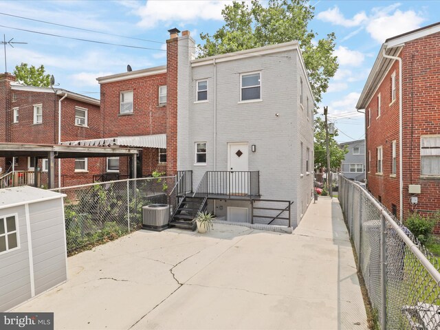 610 Galveston Pl SE, Washington, DC 20032 - back of house with brick siding, central AC, a chimney, and a patio area