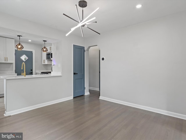 610 Galveston Pl SE, Washington, DC 20032 - unfurnished living room featuring arched walkways, dark wood-style flooring, baseboards, recessed lighting, and a chandelier