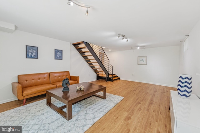 2937 Fort Baker Dr SE, Washington, DC 20020 - living area featuring track lighting, stairway, light wood-type flooring, and baseboards